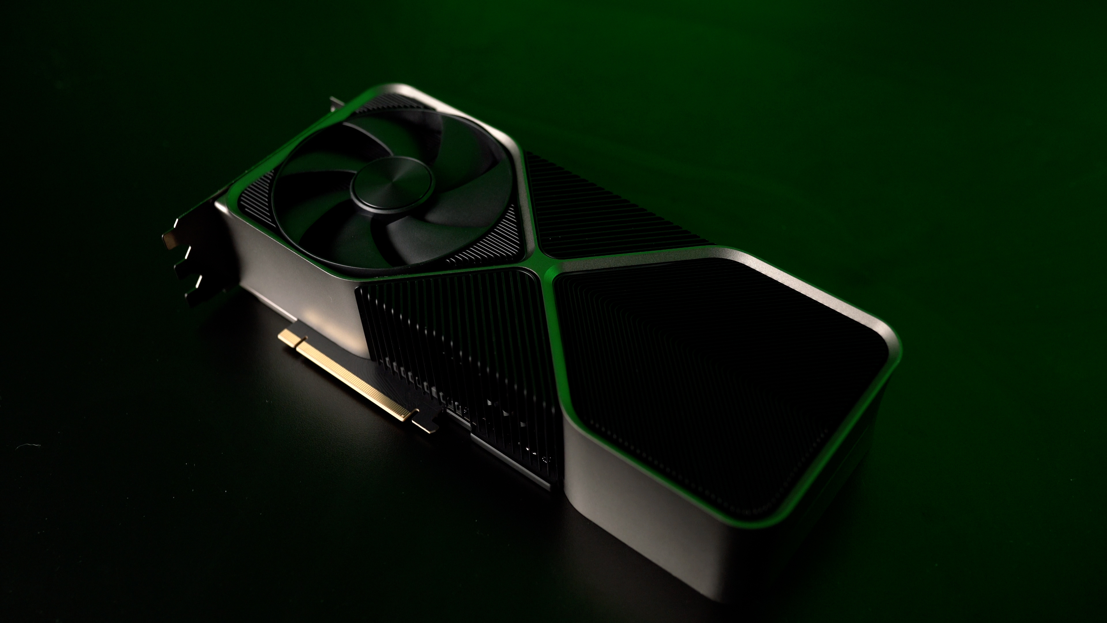 The RTX 4090 graphics card sitting on a table with a dark green background.