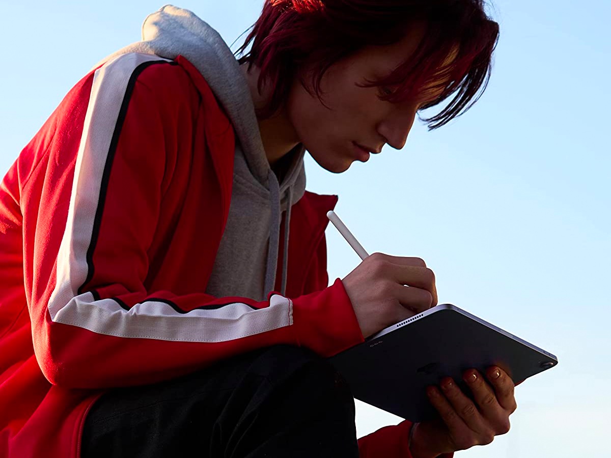 Eine junge Frau arbeitet mit ihrem Apple Pencil an einem Apple iPad Air.