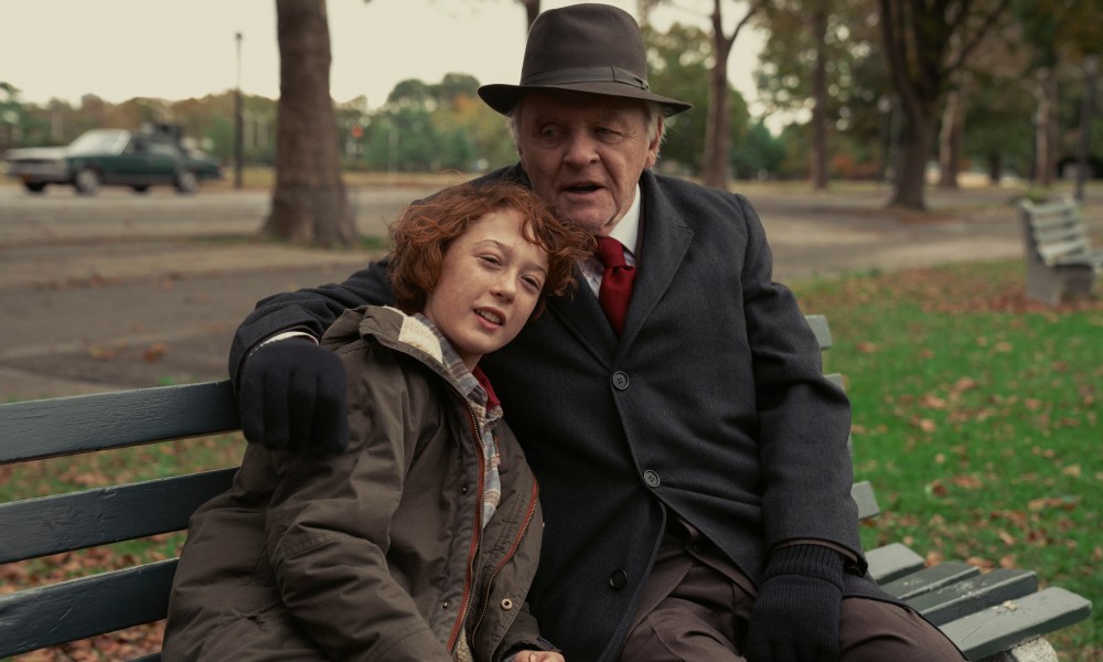 Anthony Hopkins and Banks Repeta sit on a park bench together in Armageddon Time.