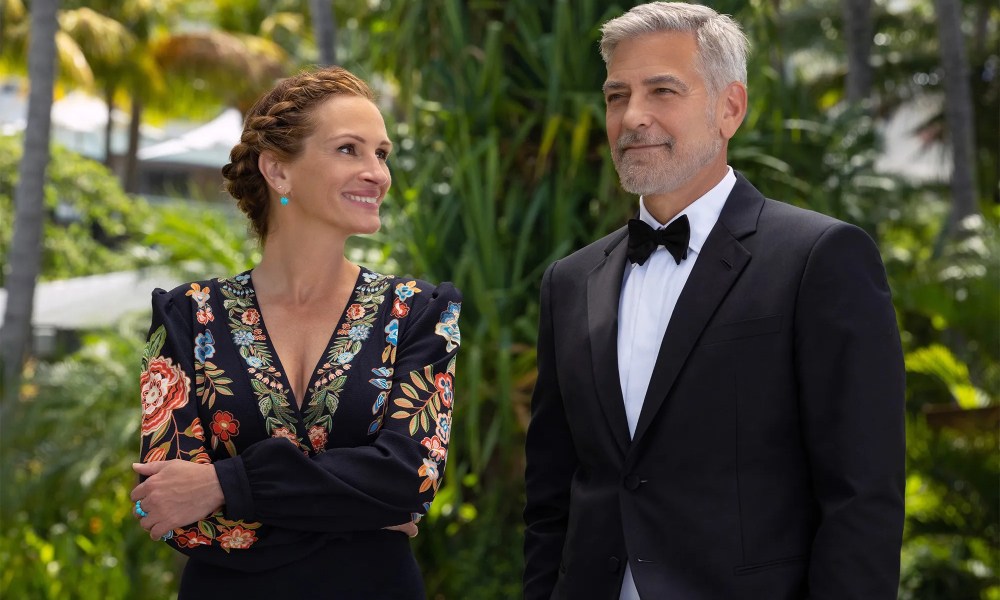 Julia Roberts smiles while looking at George Clooney in Ticket to Paradise.