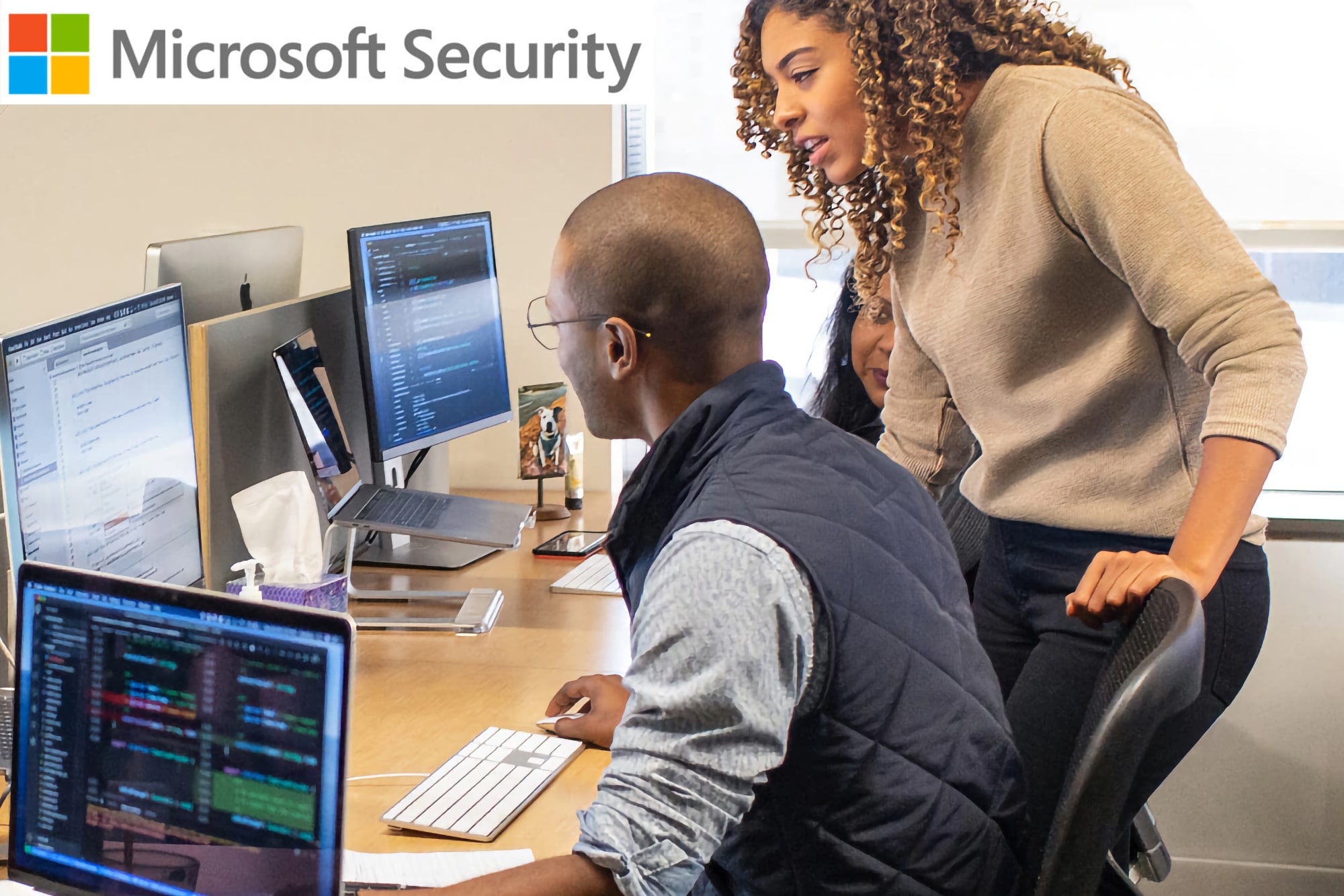 Microsoft Security logo appears in the corner of a scene with IT workers at computers