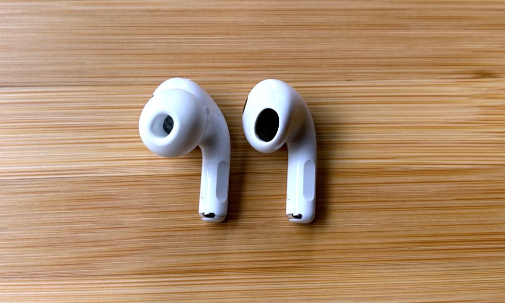 Apple AirPods Pro 2 beside an Apple AirPods 3 earbud.