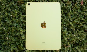 The yellow iPad (2022) lying face-down on a green bush.