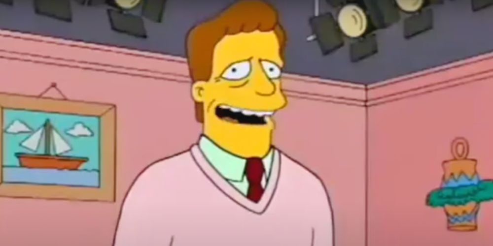 Troy McClure se tient sur une scène en train de filmer l'une de ses nombreuses vidéos