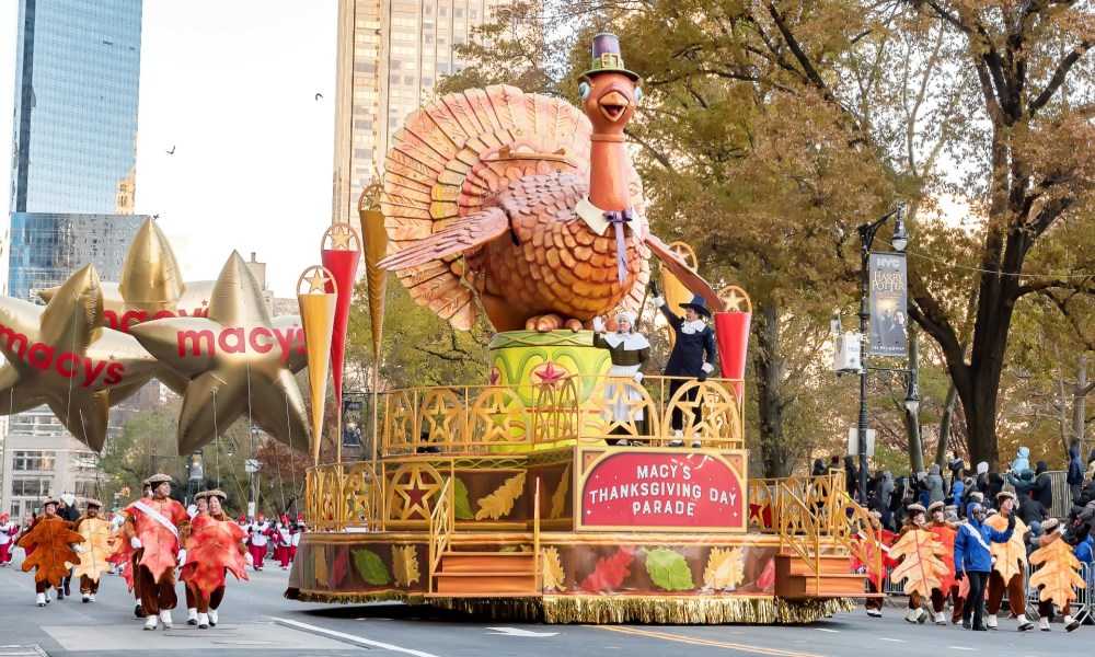 Tom the Turkey floats down the street in a Thanksgiving Day parade.