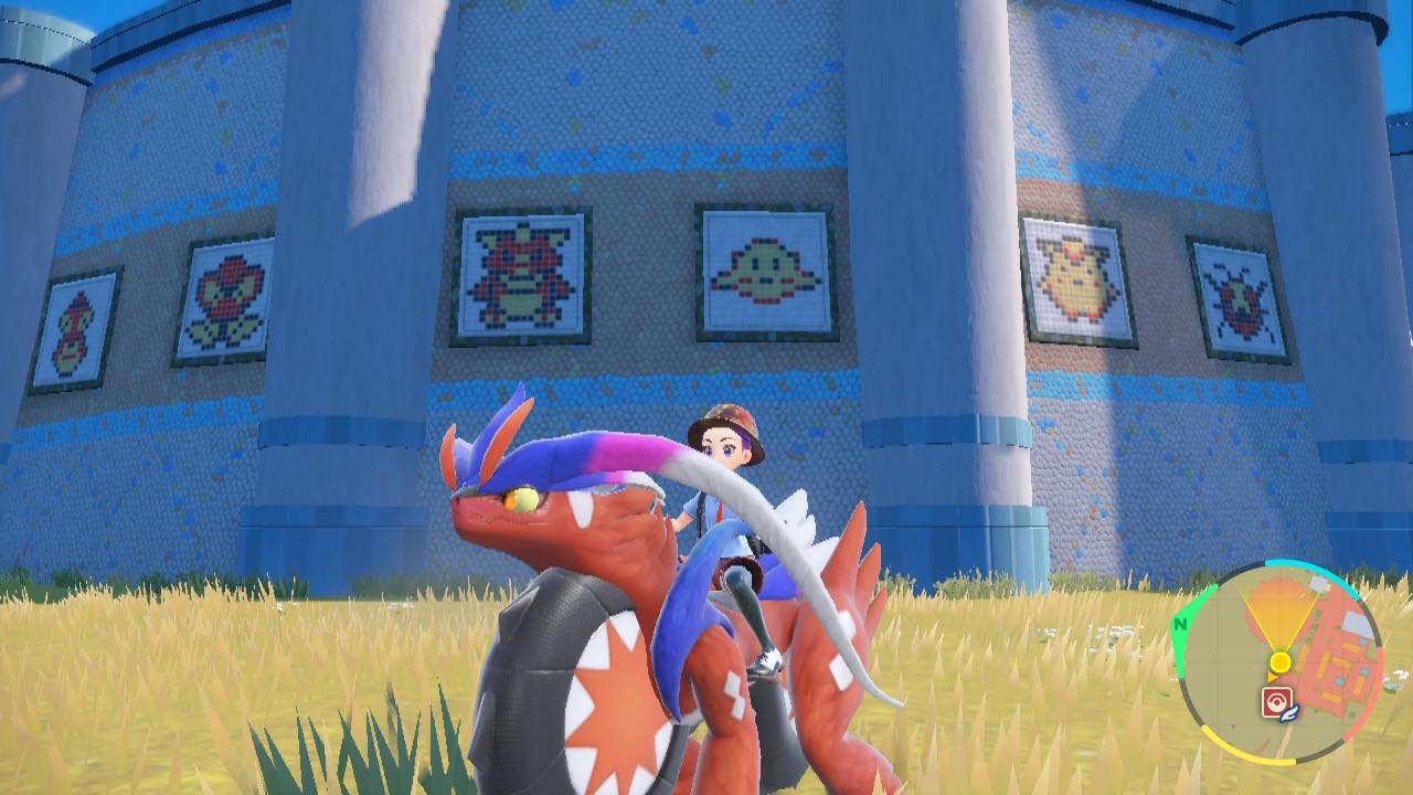 Un entraîneur de Pokémon est assis devant une peinture murale qui fait référence à Pokemon Rouge et Bleu dans Pokemon Scarlet.