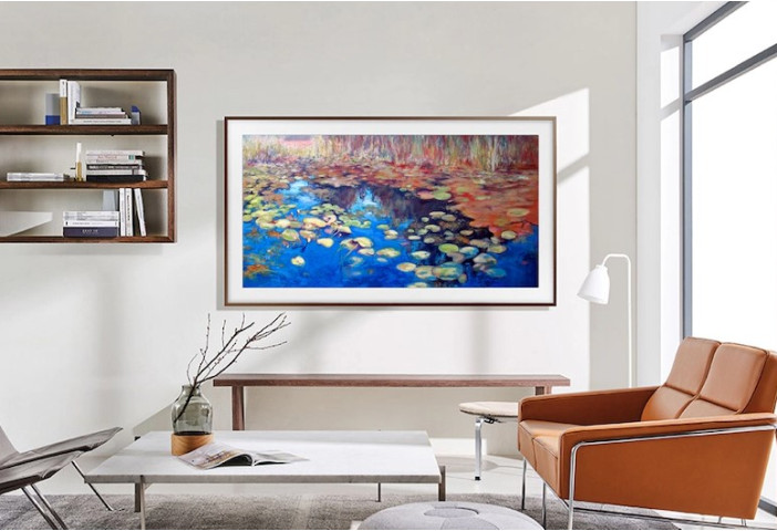 The 50-inch Samsung Frame TV hangs on a living <a href='https://caymasnewhomes.com' target='_blank'>room</a> wall displaying art.”><figcaption id=