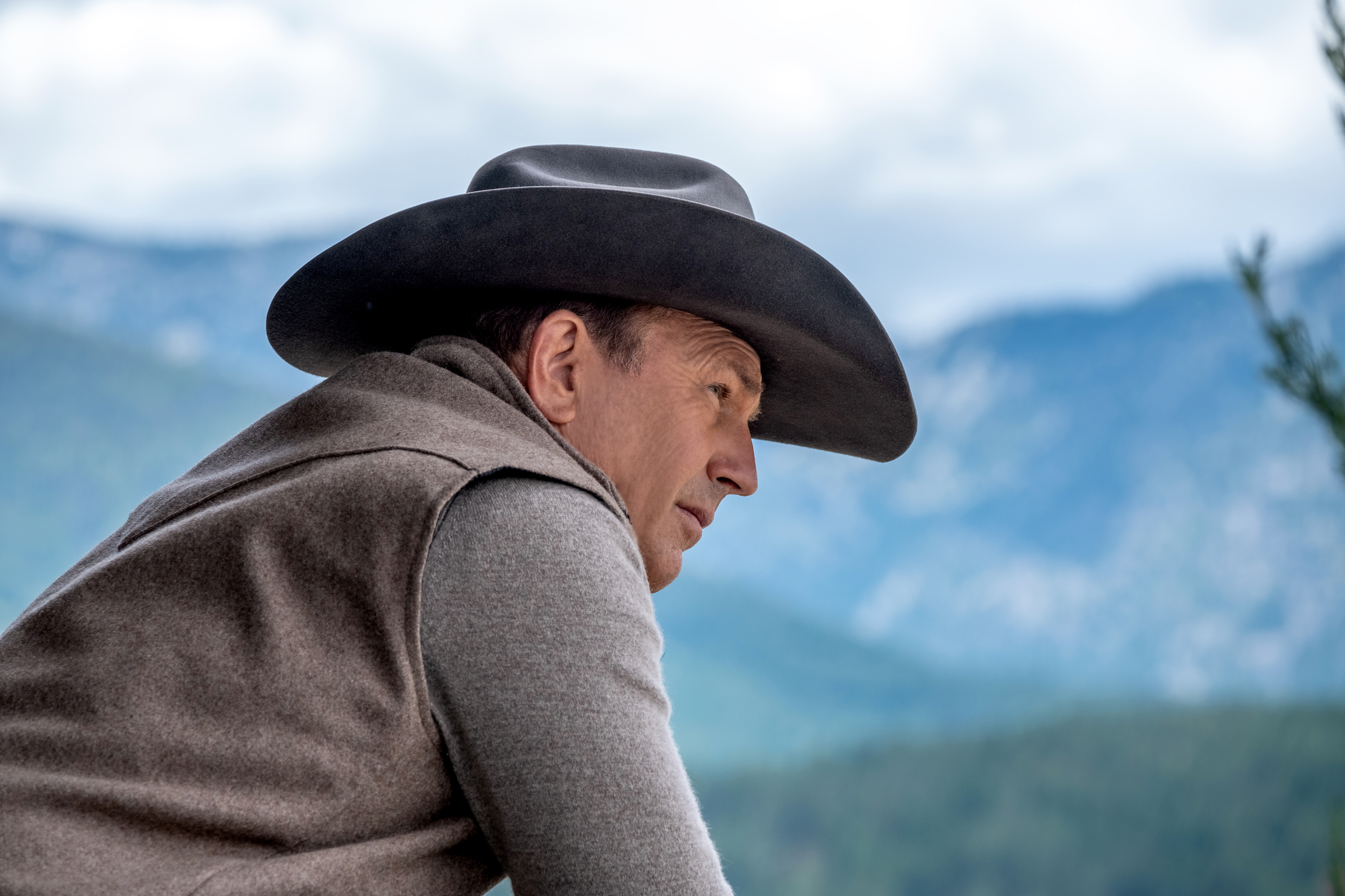 Kevin Costner se inclina sobre una valla en Yellowstone.