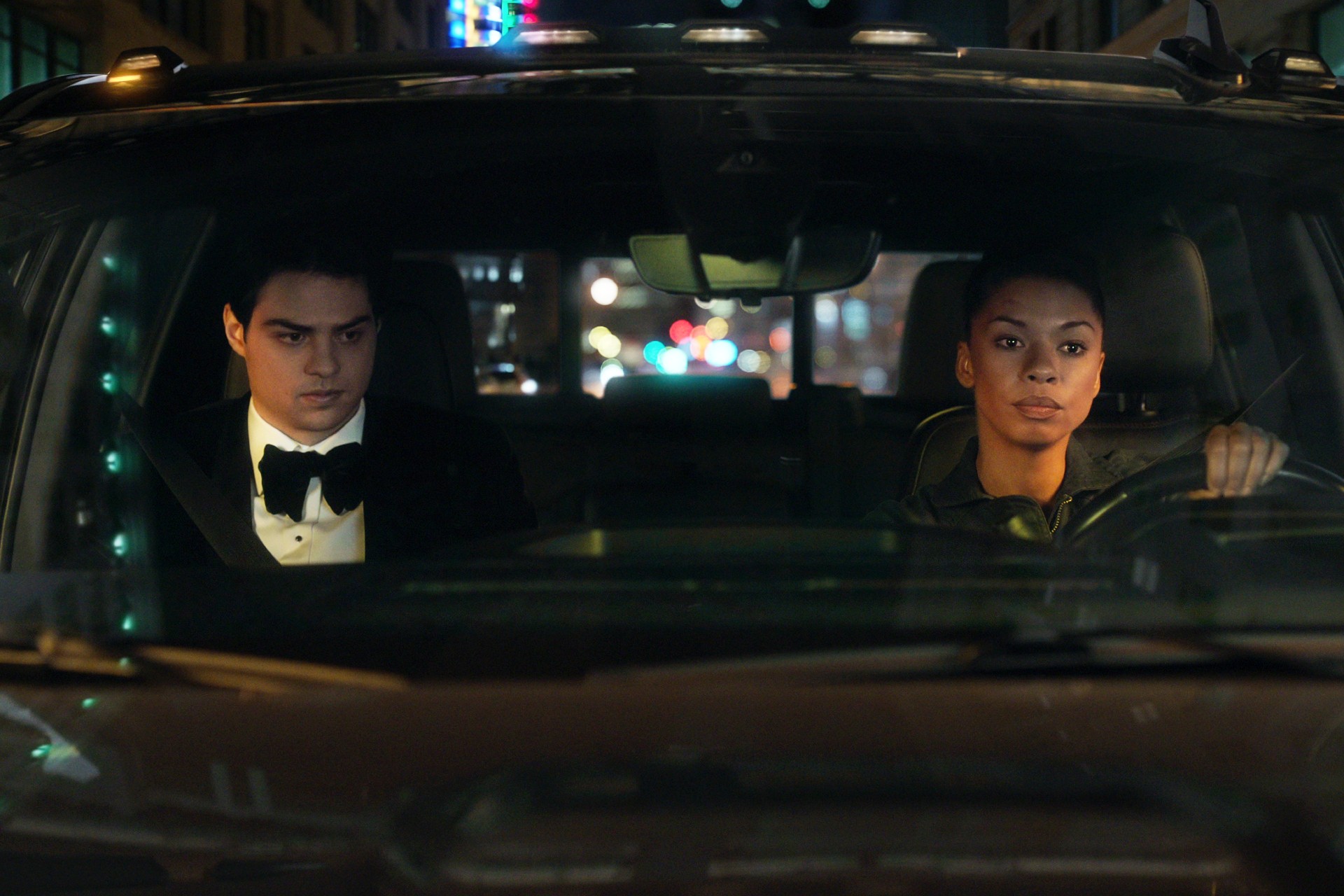 Un homme et une femme conduisent une voiture dans The Recruit.