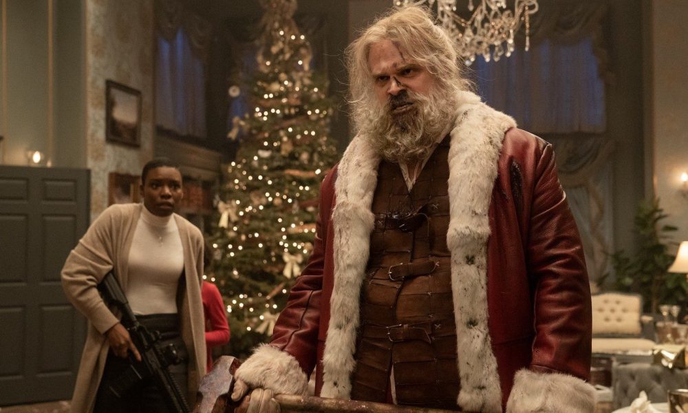 David Harbour dressed as Santa Claus, holding a sledgehammer.