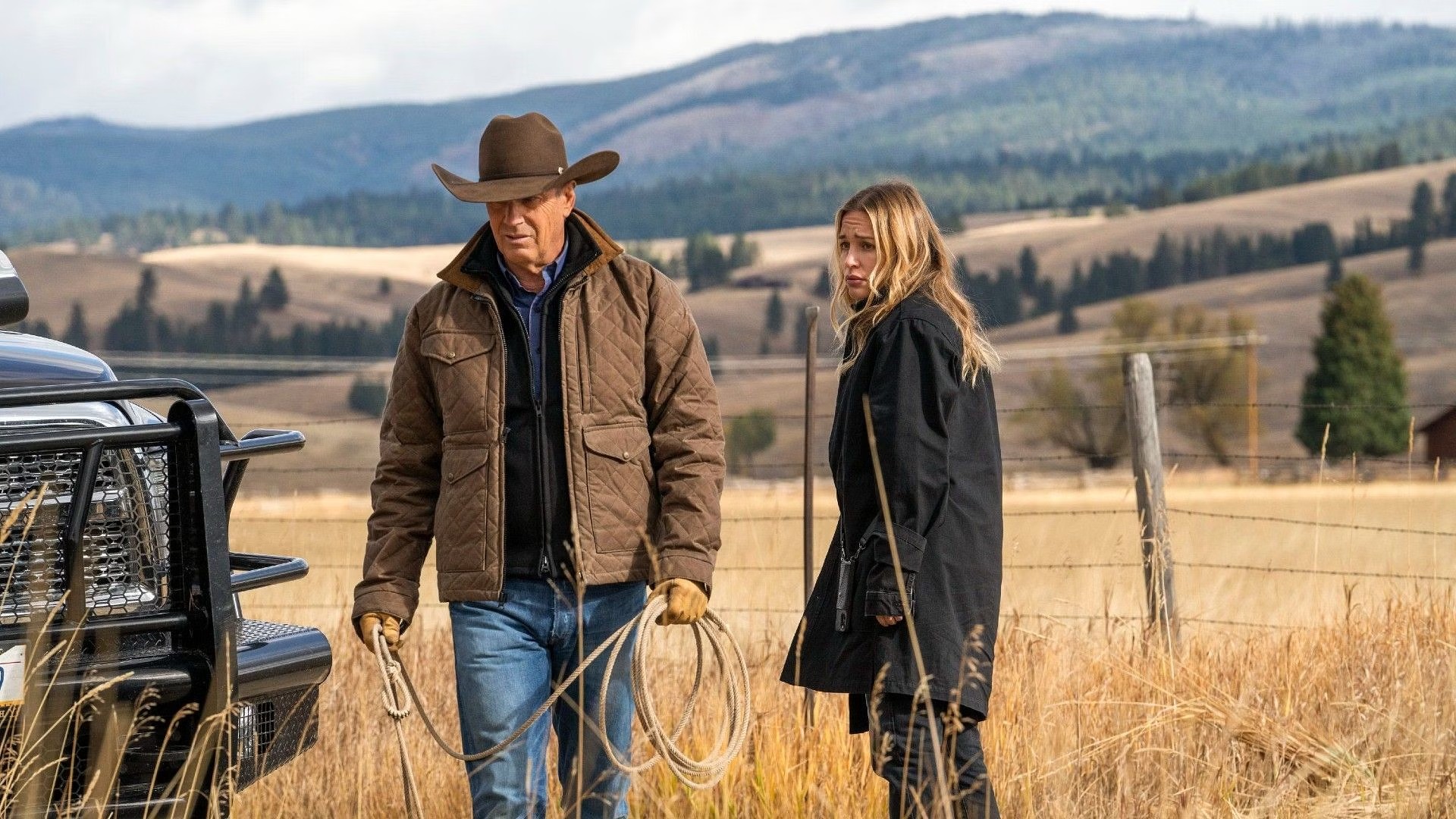 John Dutton y una mujer en un campo en Yellowstone.