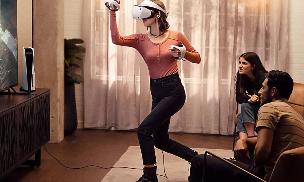 A woman using Sony PlayStation VR 2 while friends watch on the TV.