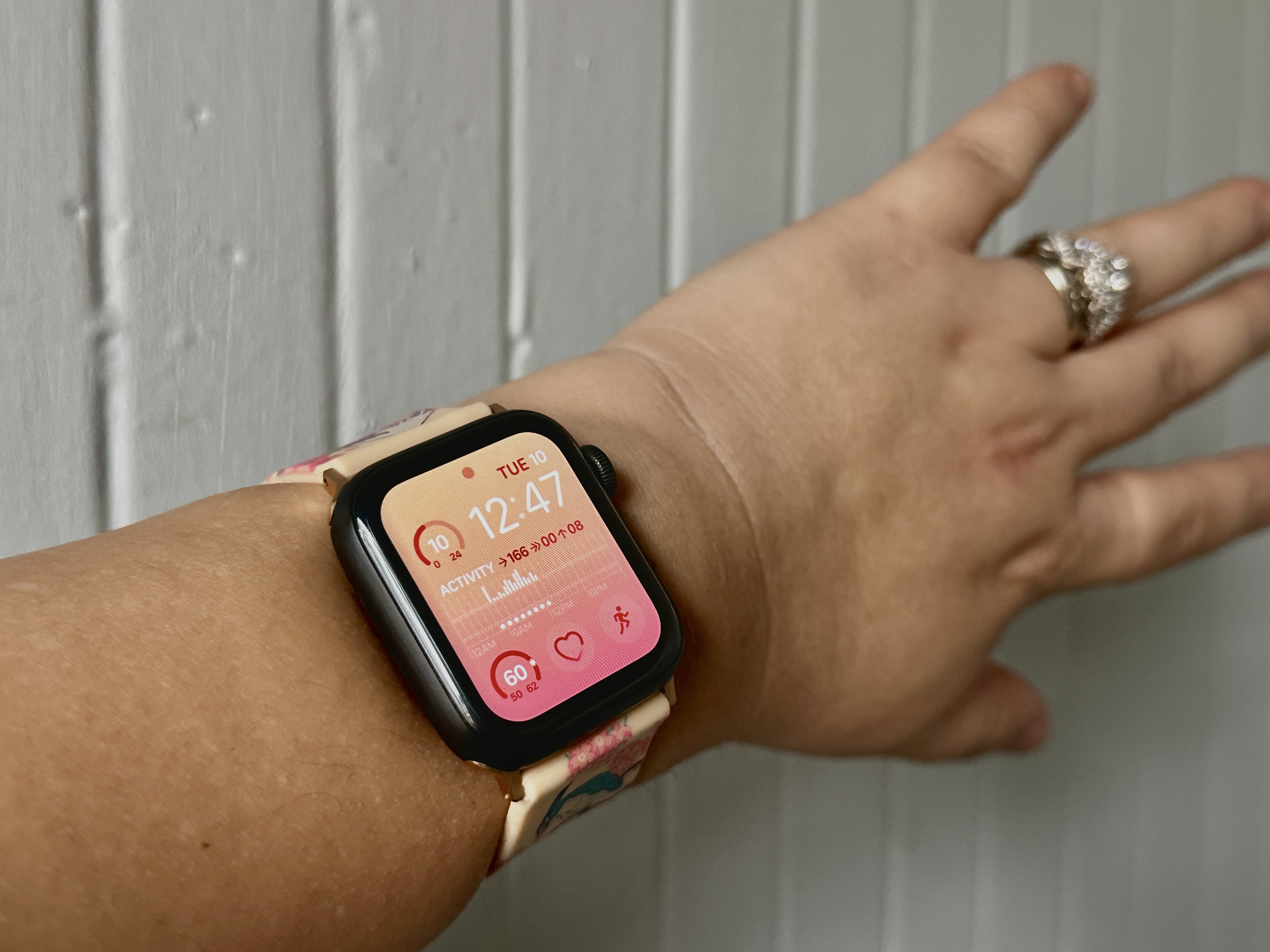 Apple Watch Series 5 au poignet avec un cadran de montre modulaire dégradé rose