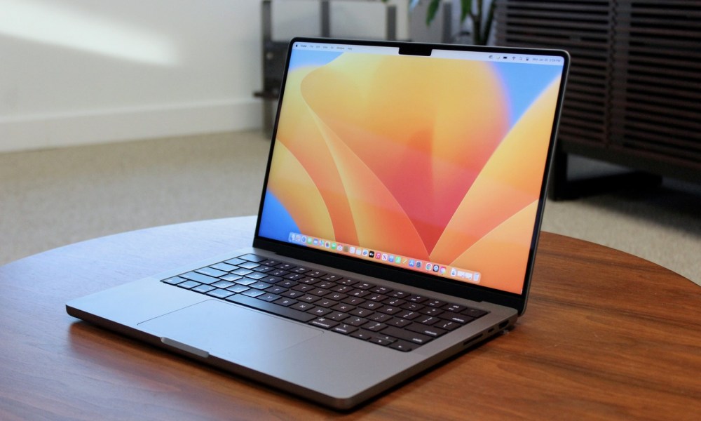 The MacBook Pro open on a wooden table.