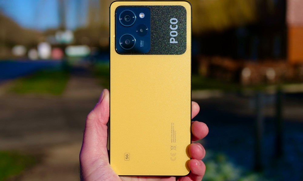 The back of the Poco X5 Pro, held in a person's hand.