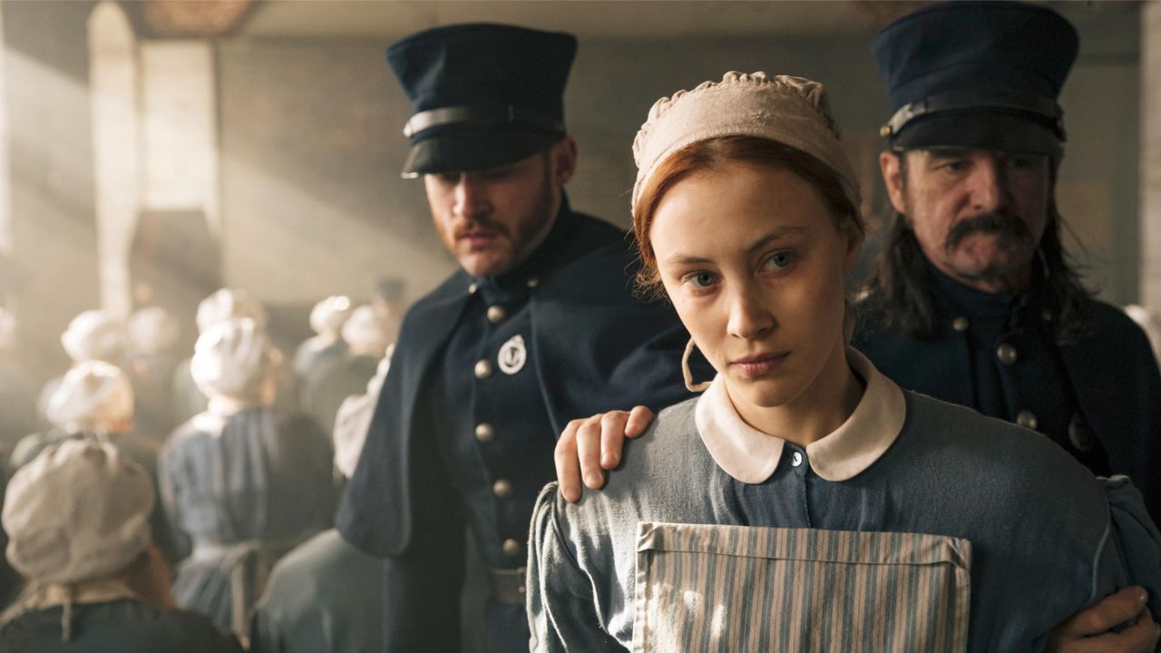 Grace Marks emmenée par deux officiers dans l'émission Alias ​​Grace.