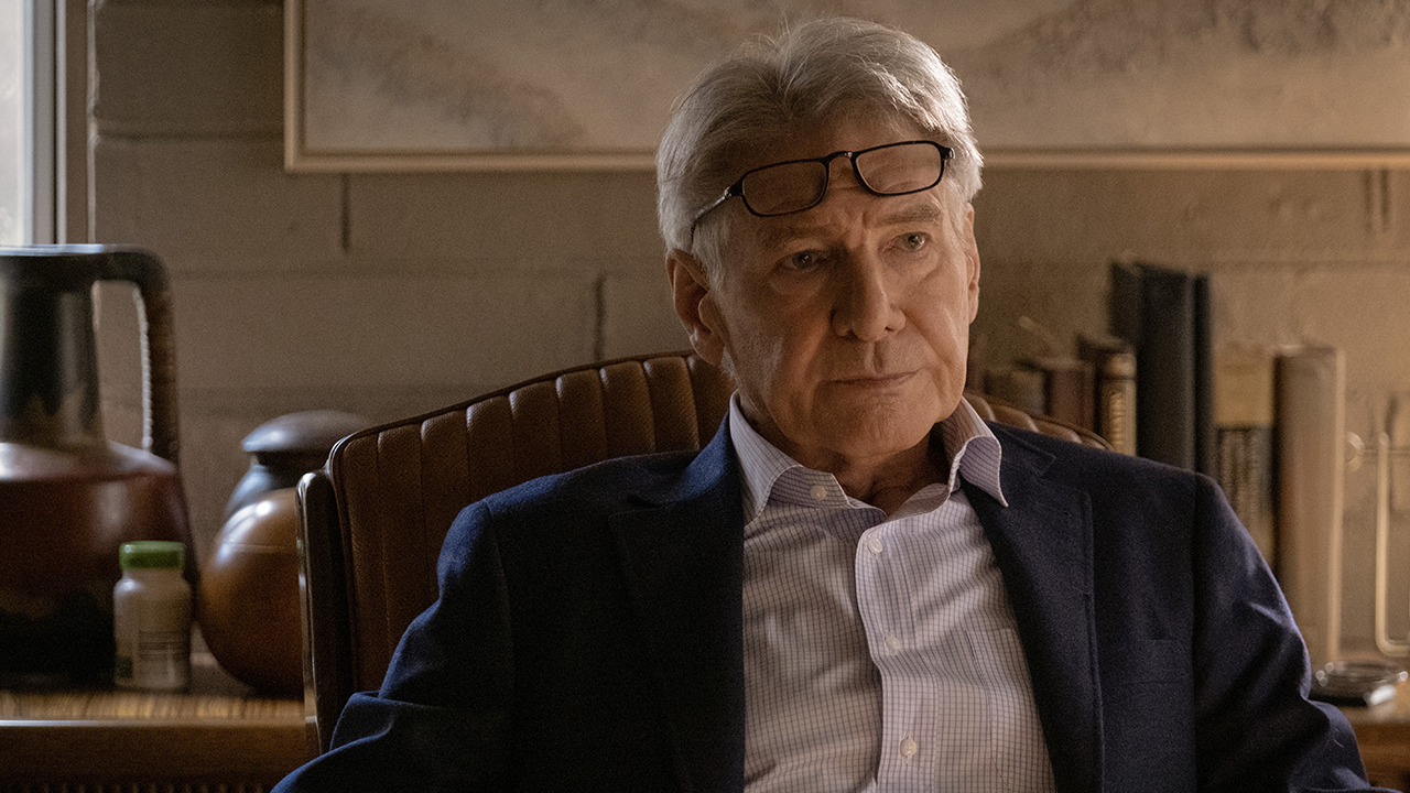 Harrison Ford assis, des lunettes sur le front dans une scène de Shrinking.