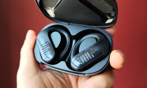 JBL Endurance Peak III in their charging case, hand-held.