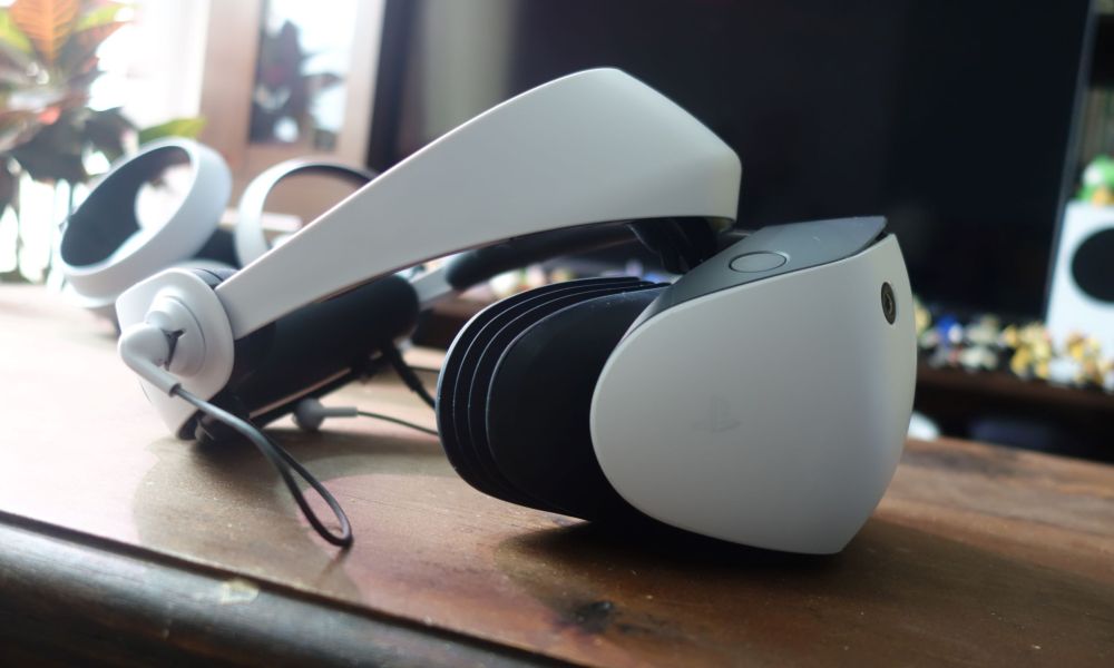 A side view of the PlayStation VR2, which sits on a wood table.