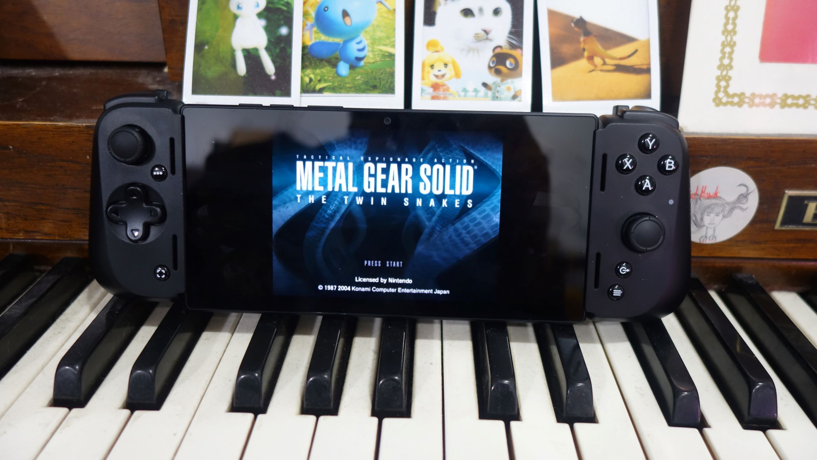 Ein Razer Edge sitzt auf einem Klavier, auf dem Metal Gear Solid: The Twin Snakes zu sehen ist.