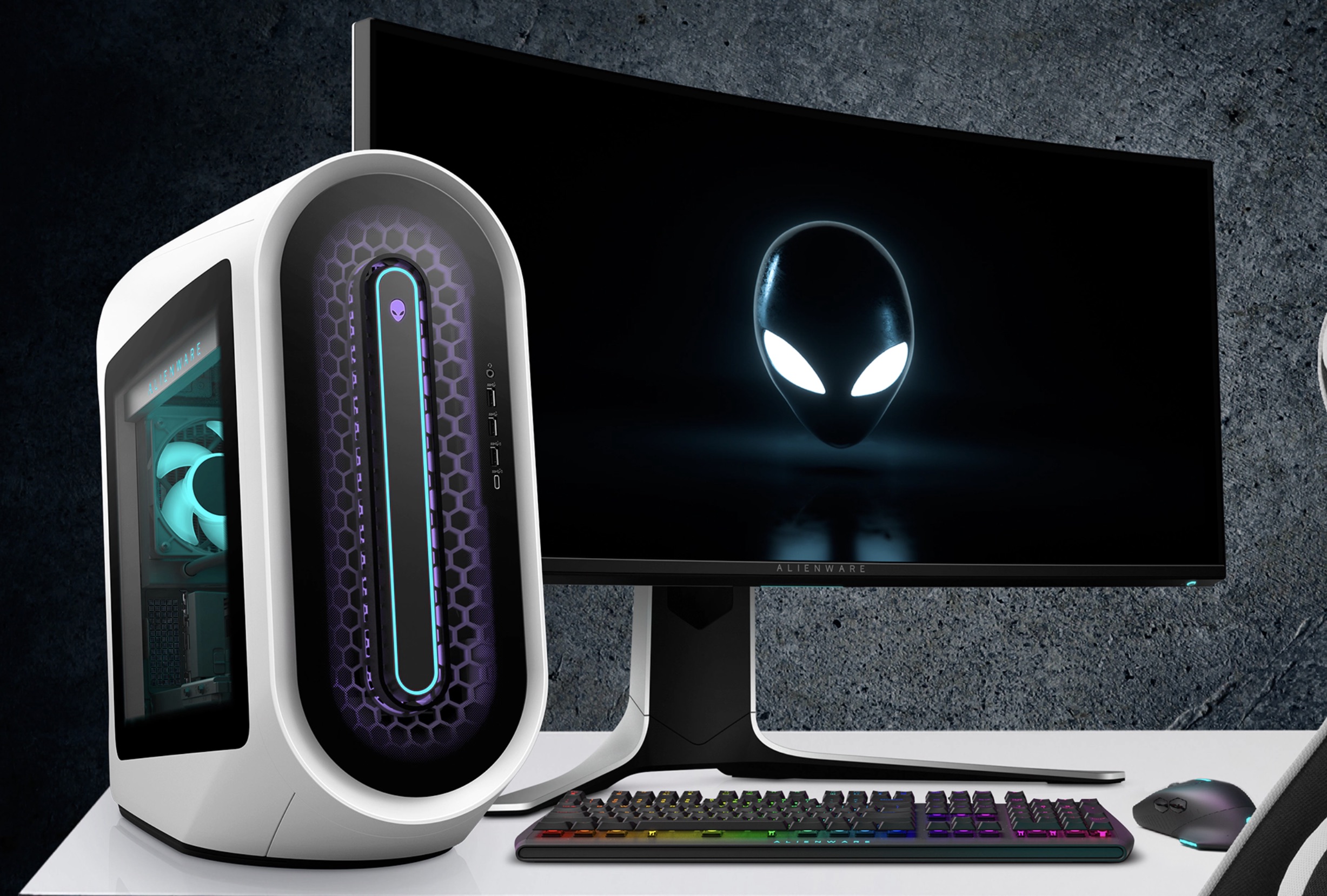 Игровой компьютер Alienware Aurora R13 на столе рядом с монитором.