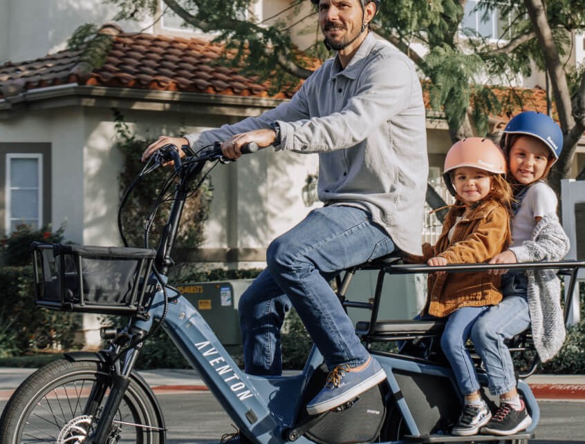 Aventon Abound ebike with kids riding in cargo rack.