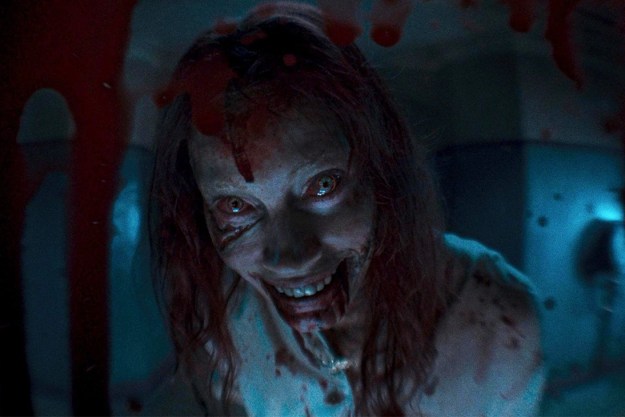 A zombie looks in a peep hole in Evil Dead Rise.