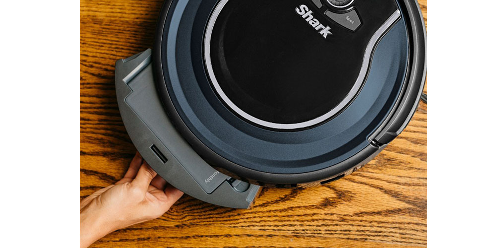 A close up of the Shark Ion Robot RV761 robot vacuum on a hard wood floor.