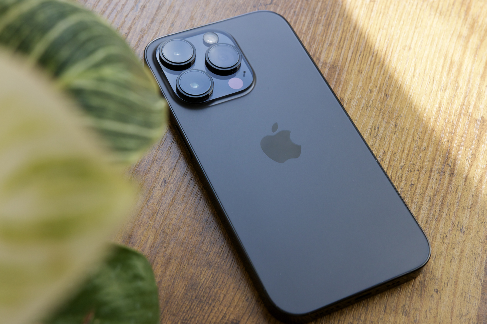 A black iPhone 14 Pro lying on a table.