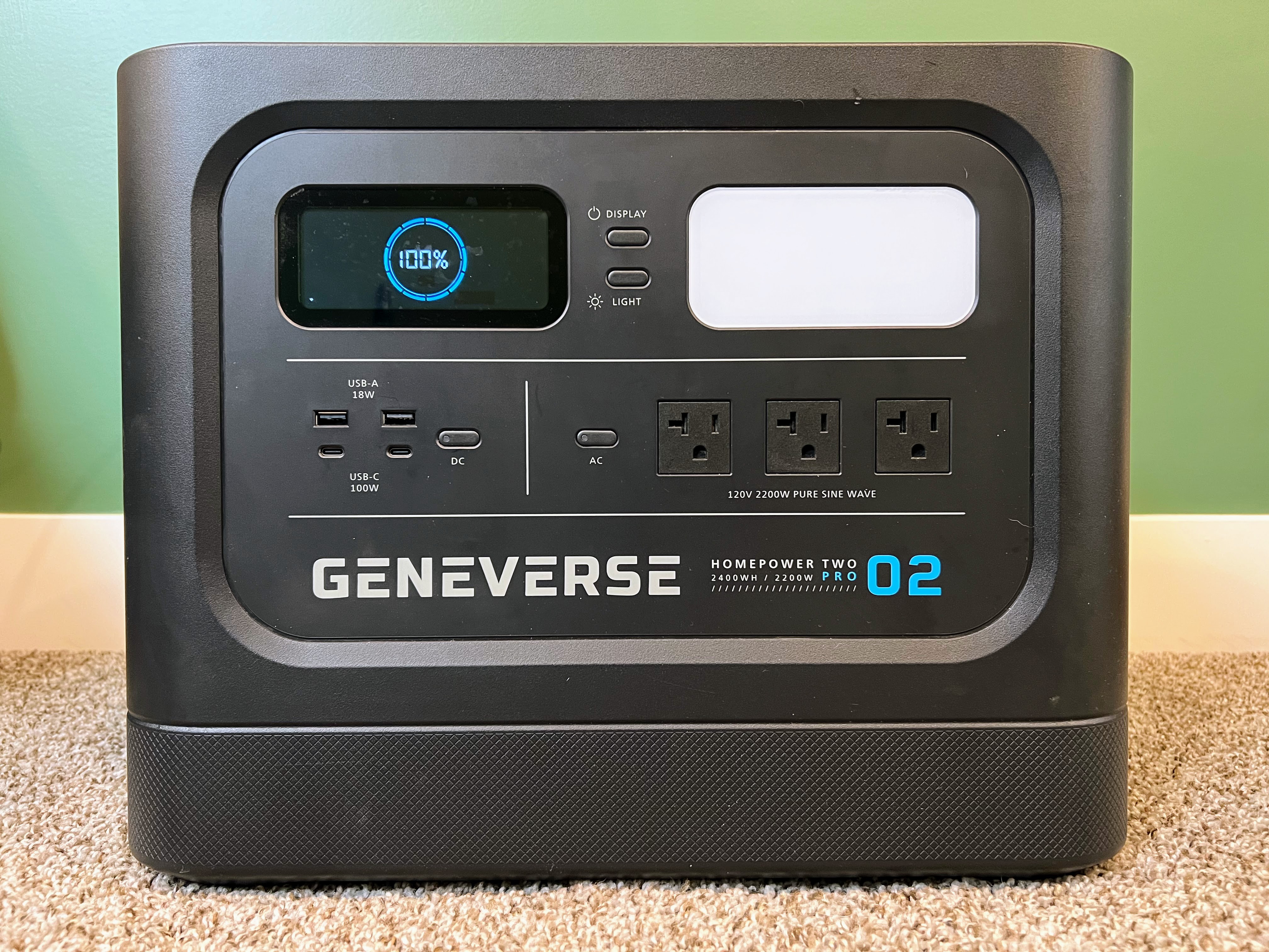 Электростанция Geneverse HomePower Two Pro установлена ​​перед зеленой стеной.