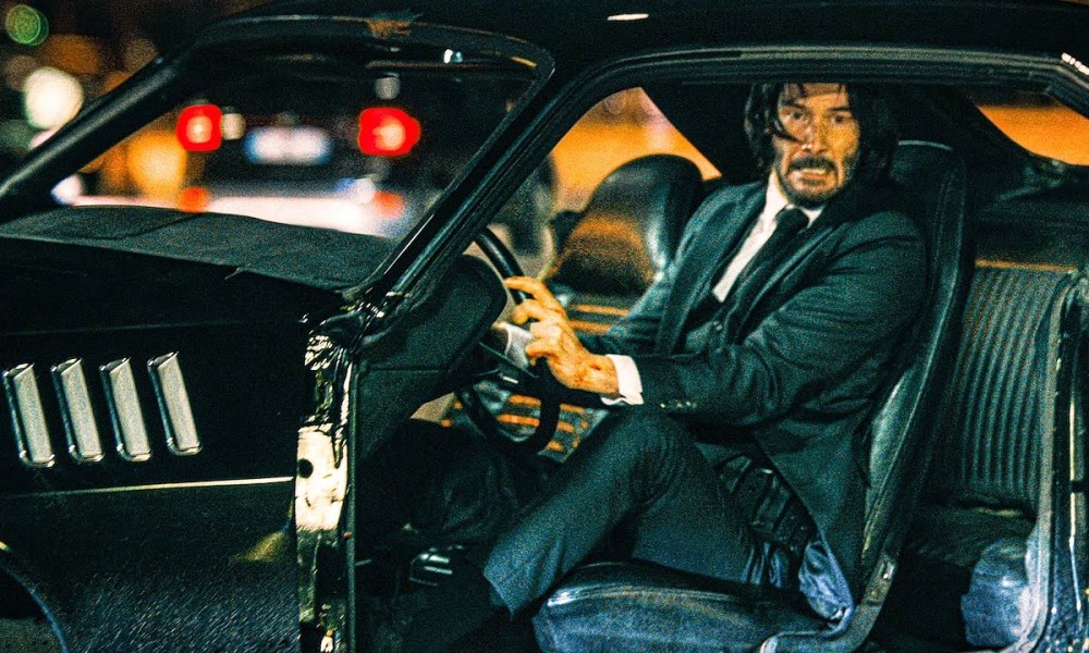 John Wick drives a car in John Wick 4.