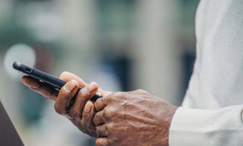 An elderly person holding a phone.