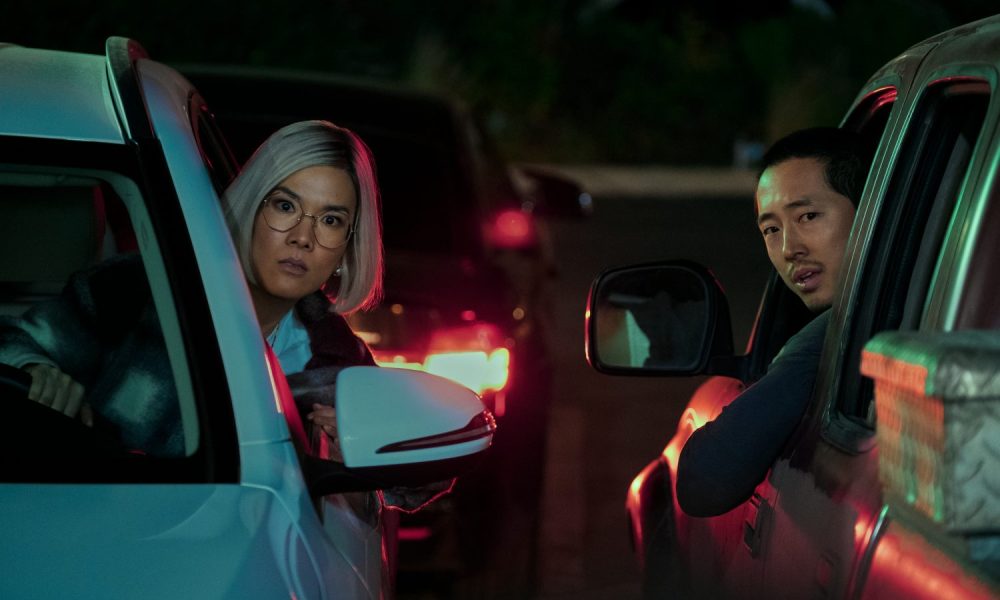 Ali Wong and Steven Yeun lean out of their car windows in Beef.