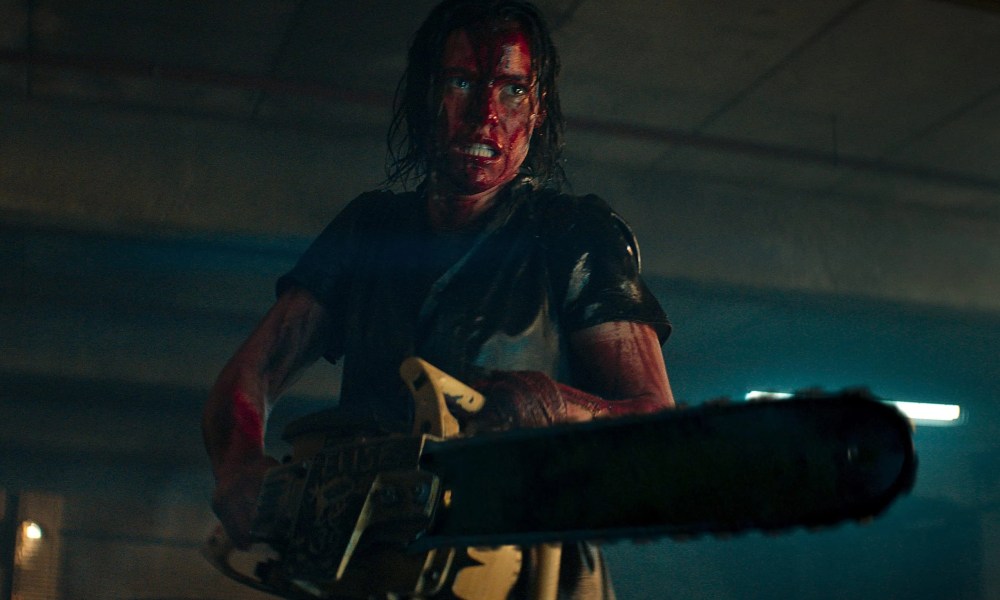 A woman wields a chainsaw in Evil Dead Rise.