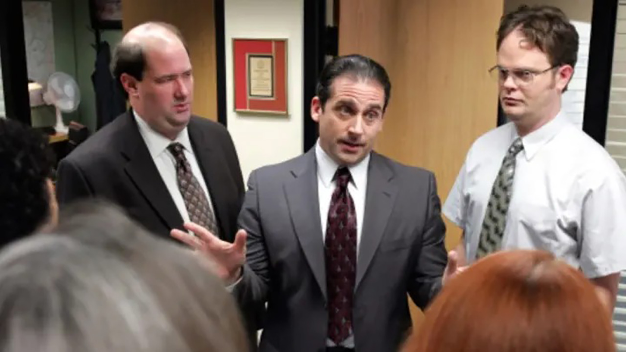 Des personnages de The Office autour de Michael Scott parlent.