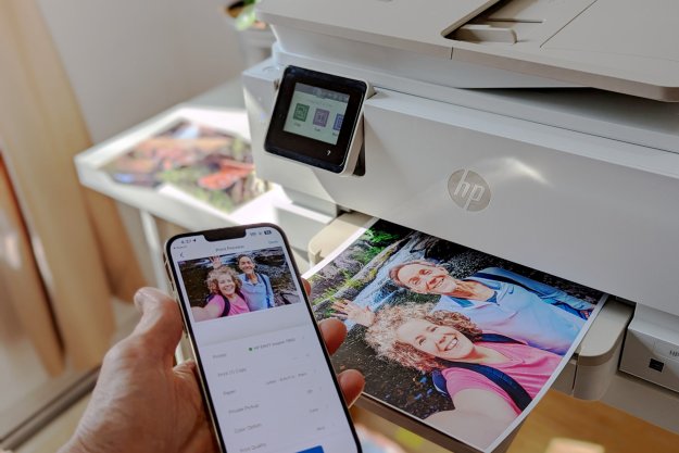 HP Envy Inspire 7955e in action, printing a full-page photo from an iPhone.