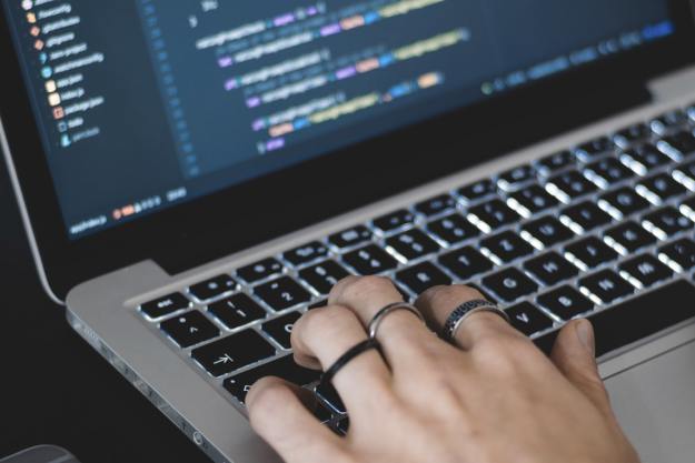 A person typing on a MacBook keyboard.