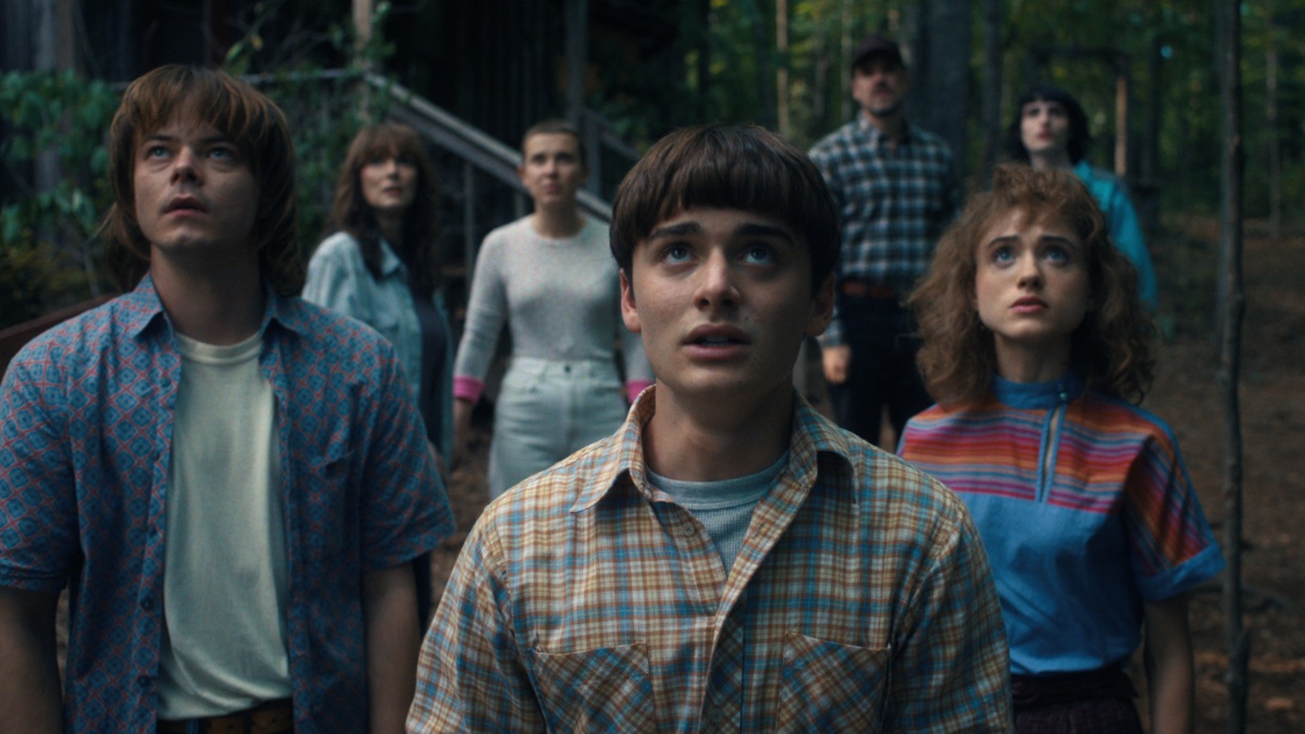 O elenco de "Stranger Things" fica um ao lado do outro e olha para cima.