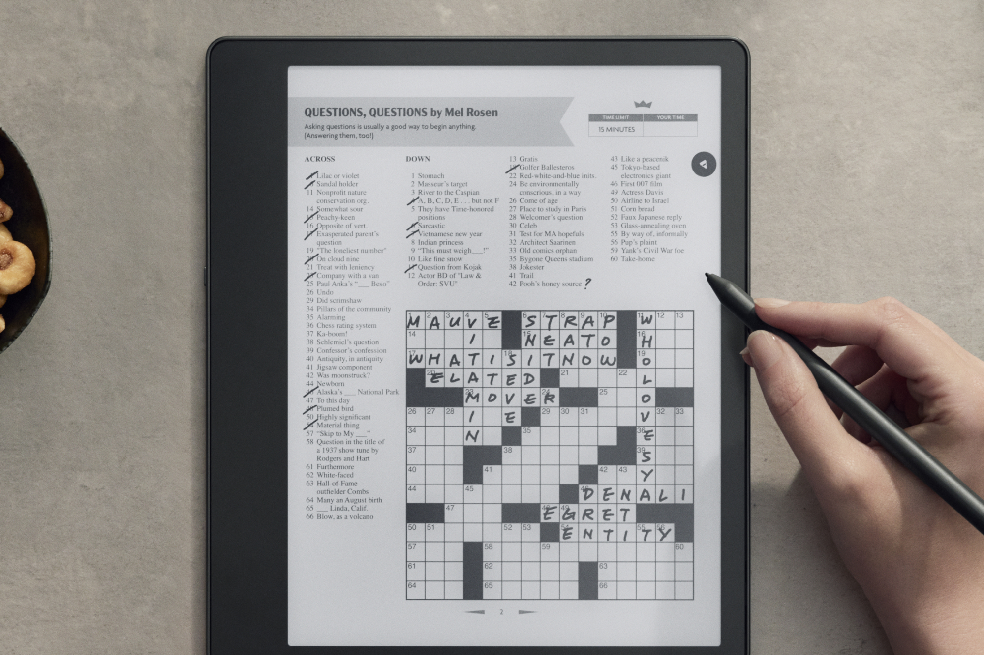 Someone doing a crossword on the Amazon Kindle Scribe.