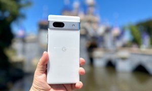 Google Pixel 7a held in hand in front of Disneyland castle