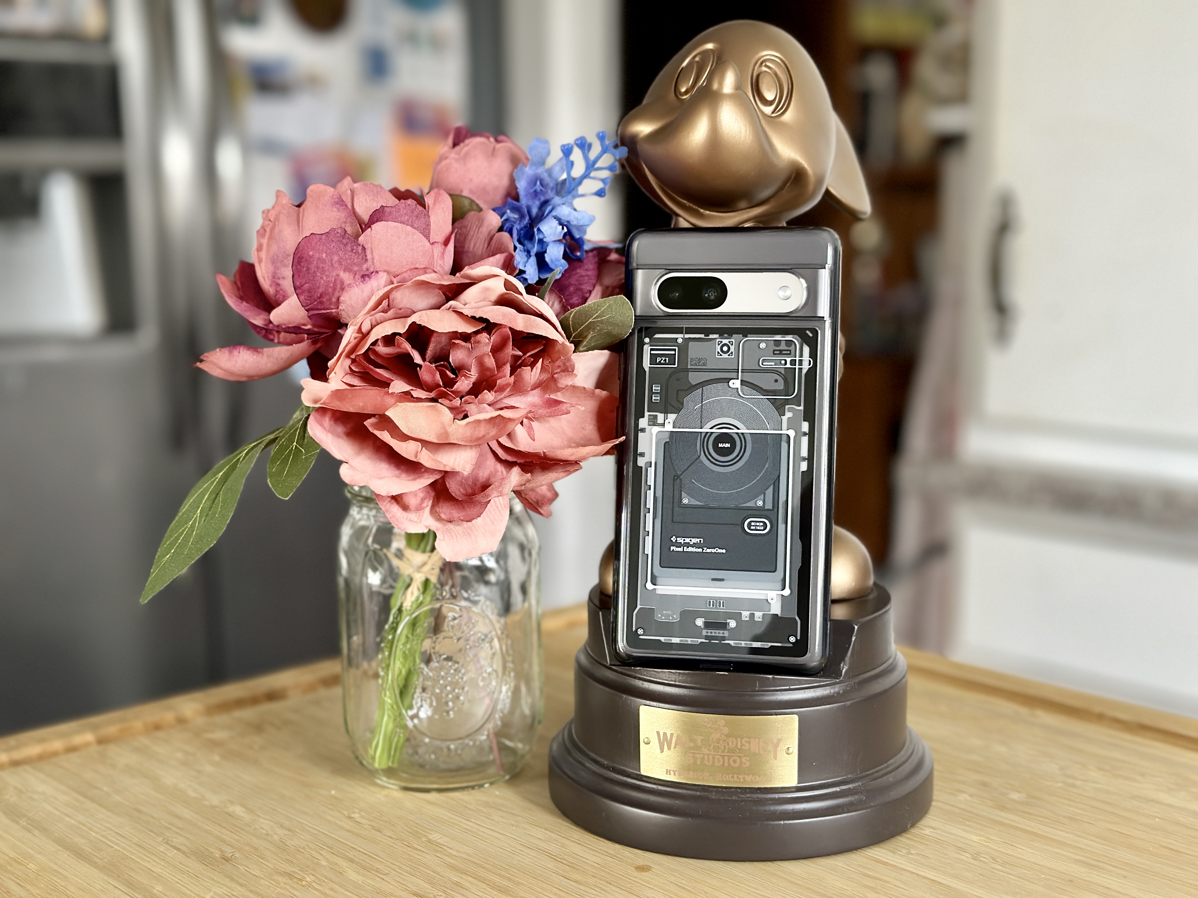 Spigen Ultra Hybrid Zero One Pixel 7a case on a Mickey phone stand with flowers