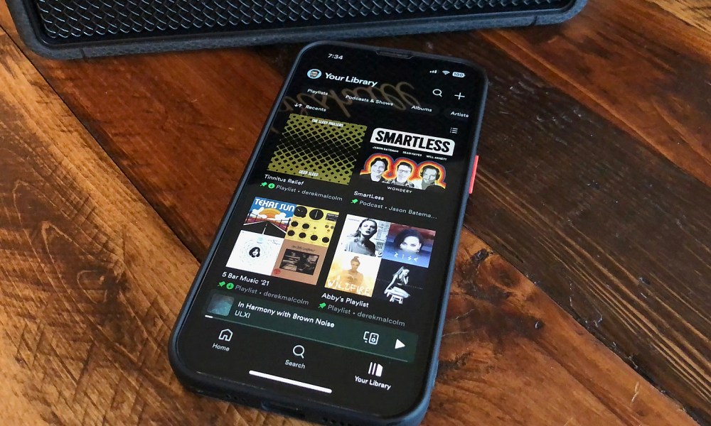 An iPhone with the Home section of the Spotify app on it.