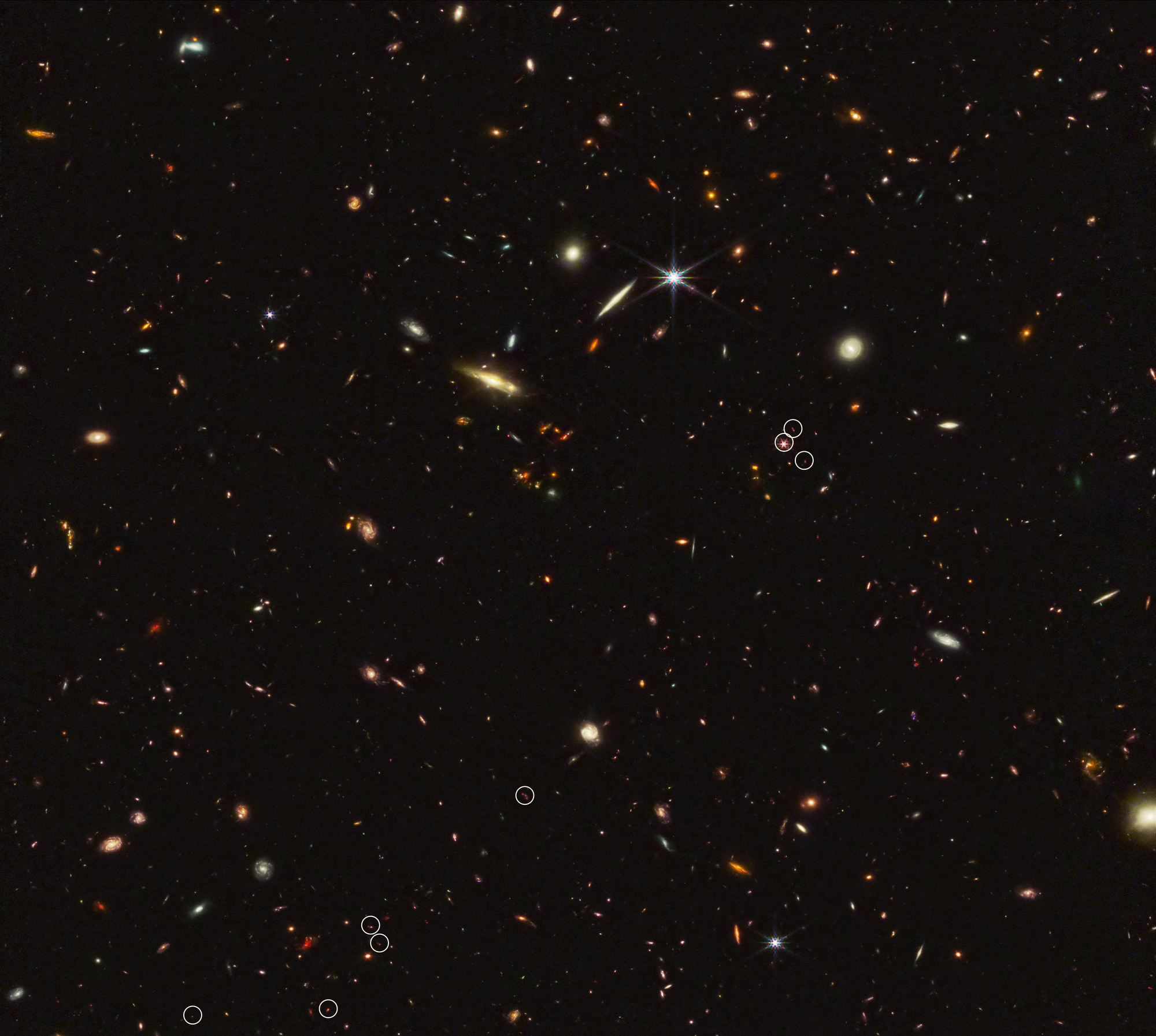 Un arrangement de 10 galaxies distantes marquées par huit cercles blancs dans une ligne diagonale filiforme.