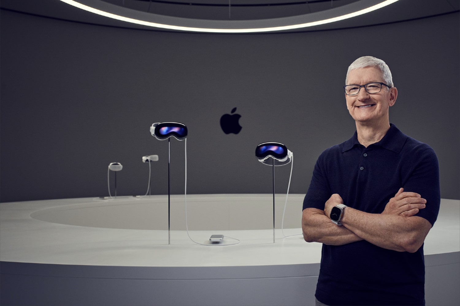 Apple CEO Tim Cook notion in front of four Vision Pro headsets.