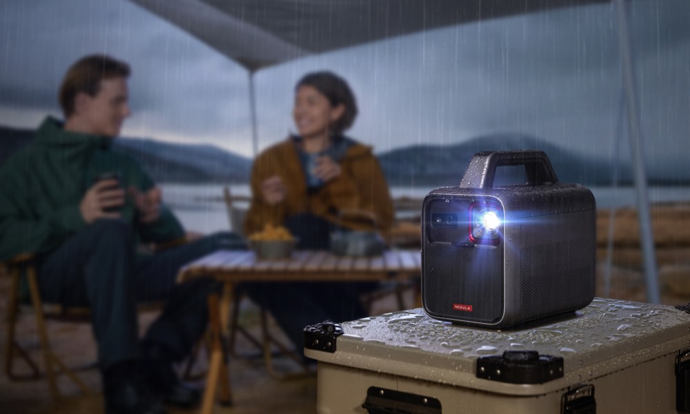 The Anker Nebula Mars 3 portable projector on a table under a tent.