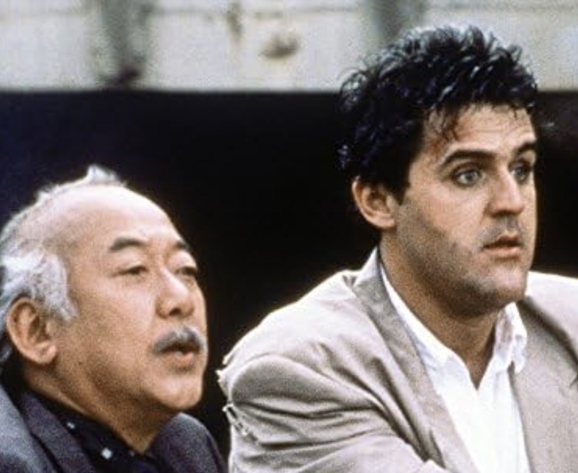 Pat Morita e Jay Leno olham com olhares confusos em Collision Course.