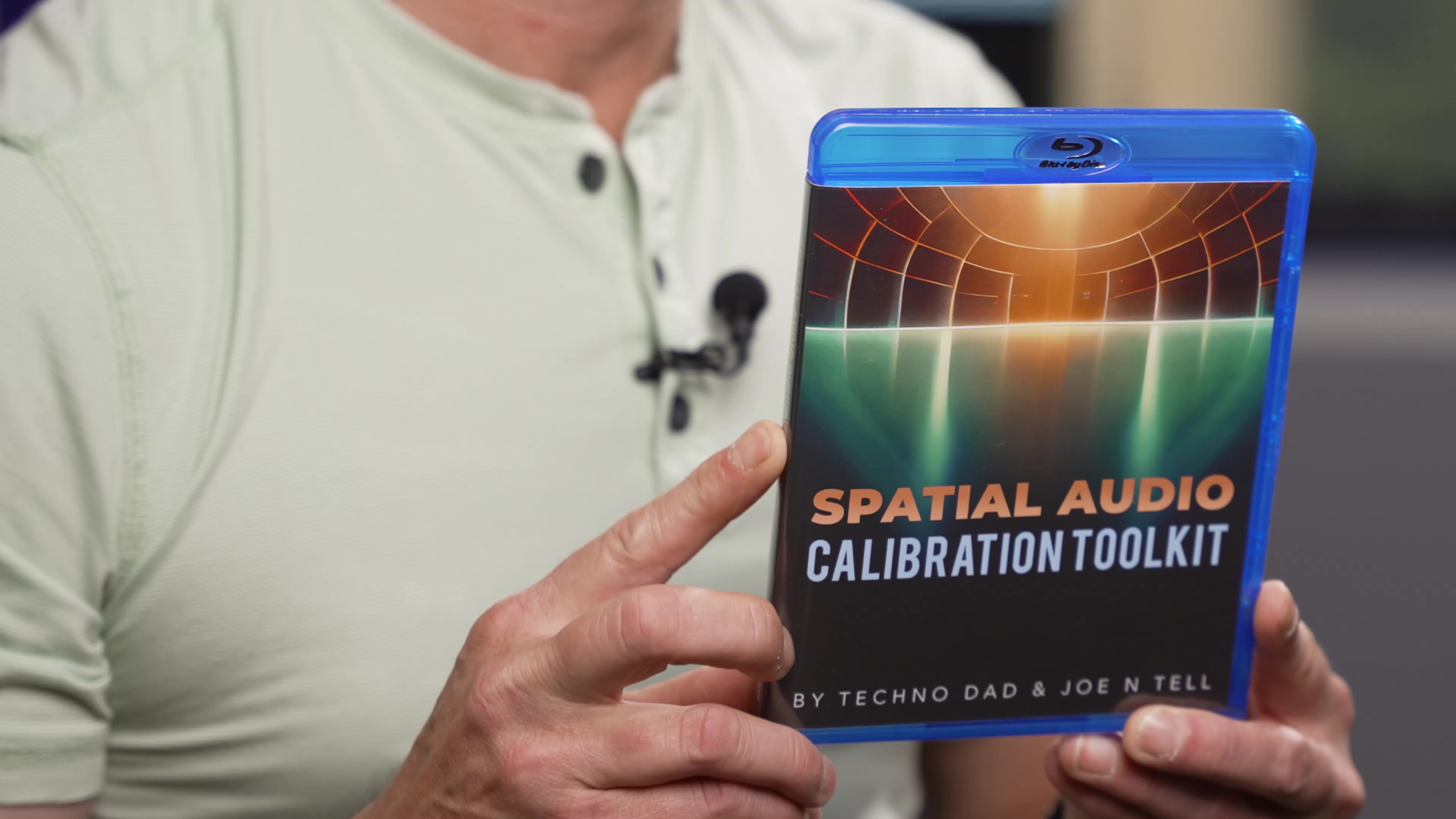 Un hombre sostiene la caja del disco Spatial Audio Calibration Toolkit.