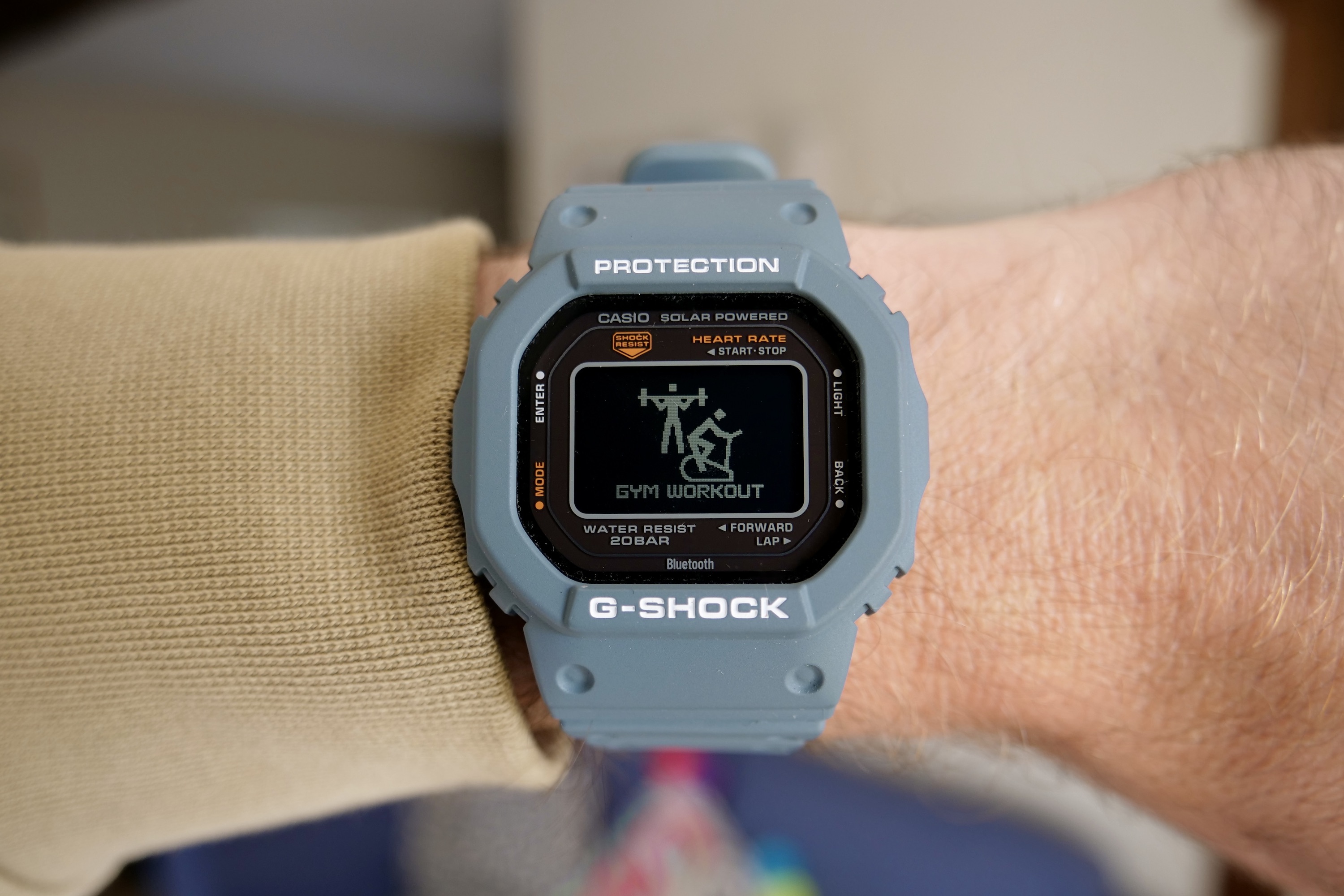 Eine Person, die die Casio G-Shock DW-H5600 trägt und den Fitness-Workout-Bildschirm zeigt.