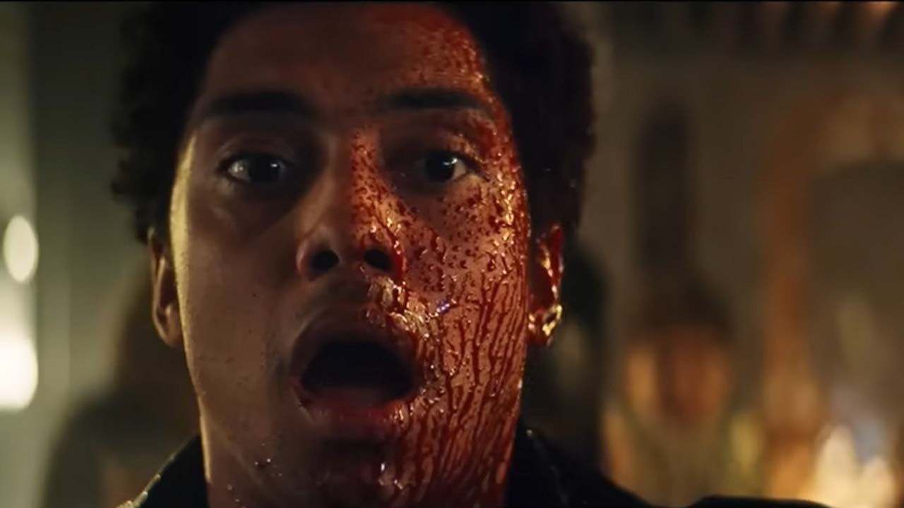 A young man with his mouth wide open, faces covered in splattered blood in a scene from Gen V on Amazon Prime Video.