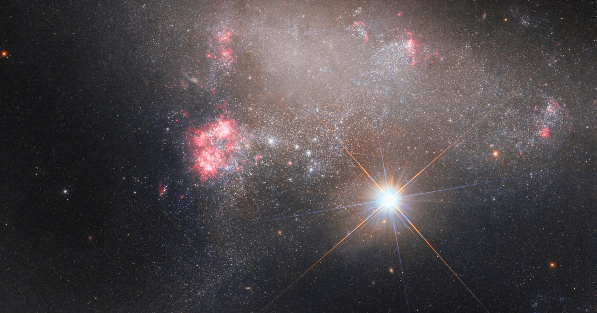 Hubble image shows star glowing over an irregular galaxy | Digital Trends